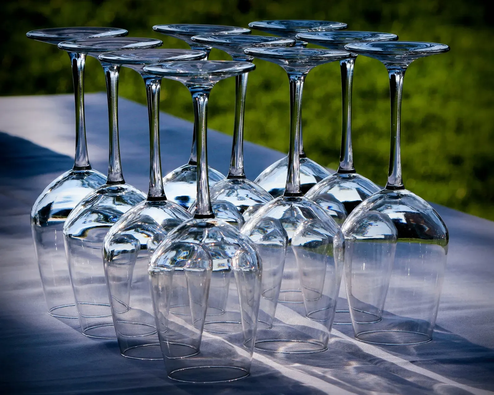 Wine glasses stood upside down in rows on an outdoor table ready for packing