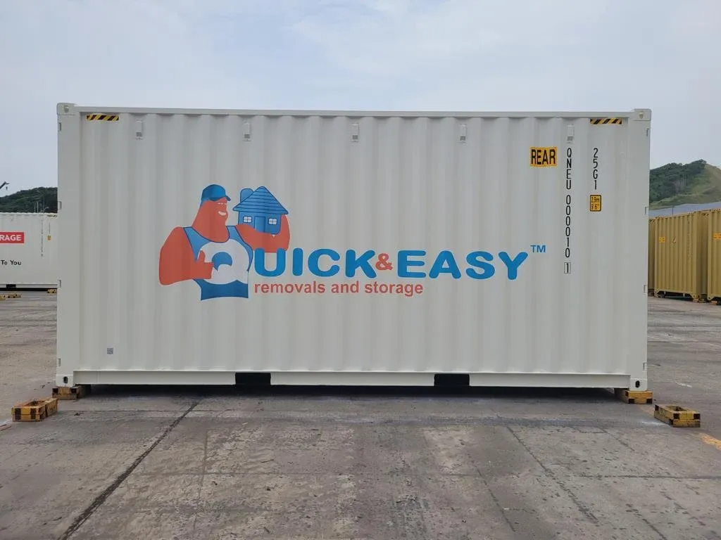 White shipping container branded with the Quick and Easy removals and storage logo in a container yard